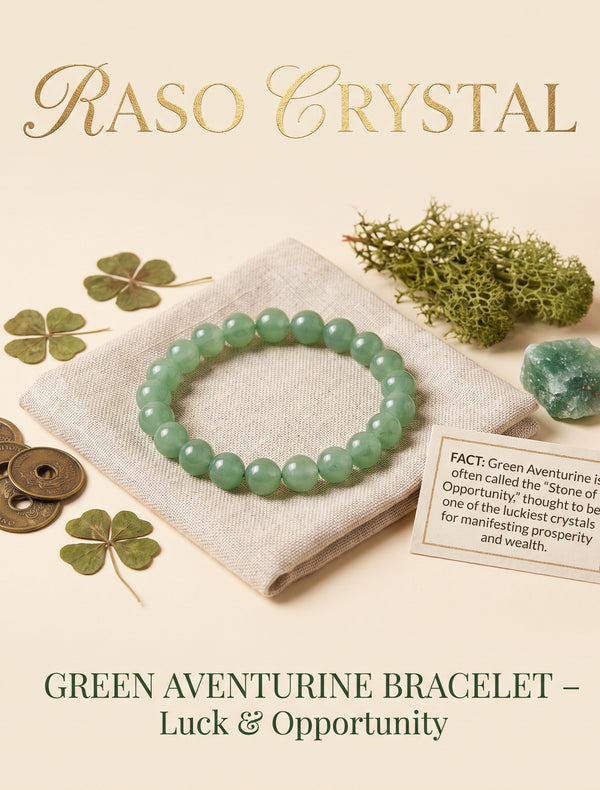 A green aventurine beaded bracelet displayed on a folded cream fabric cloth, surrounded by decorative props including four-leaf clovers, bronze coins, moss, a small polished crystal, and a fact card. The text 'RASO CRYSTAL' appears at the top and 'GREEN AVENTURINE BRACELET – Luck & Opportunity' appears at the bottom.